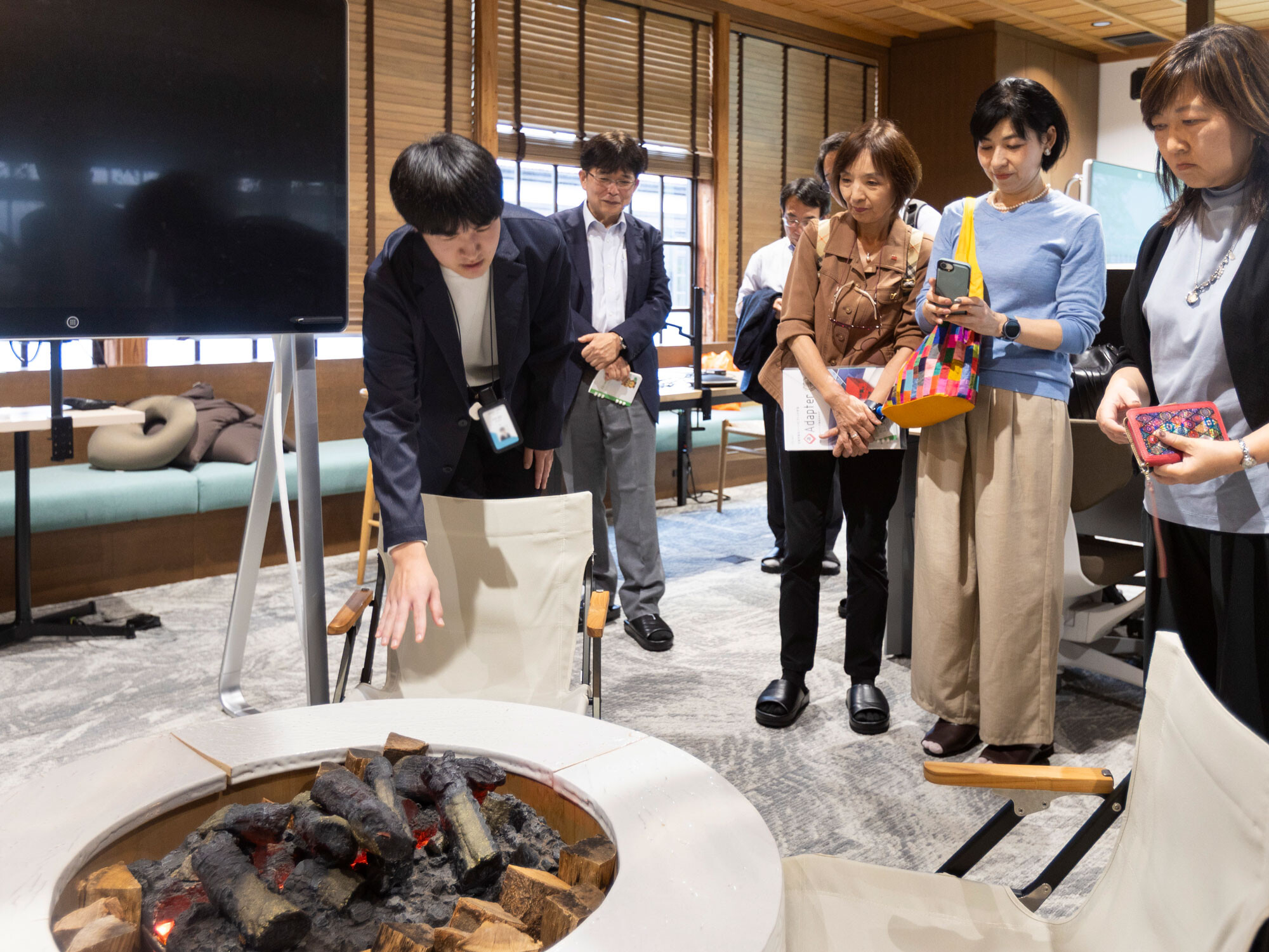 オフィスで使用されている萩焼のテーブルを紹介するメンバー